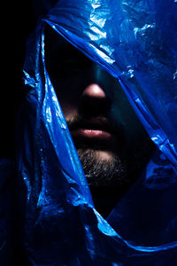 Man under plastic against black background