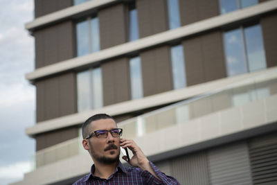 Portrait of young man against building