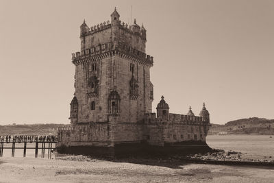 Building by sea against clear sky