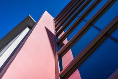 Low angle view of modern building against blue sky