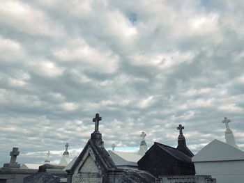 Low angle view of buildings against cloudy sky