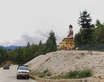 Statue against trees and sky