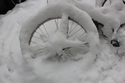 Close-up of frozen bicycle on snow field