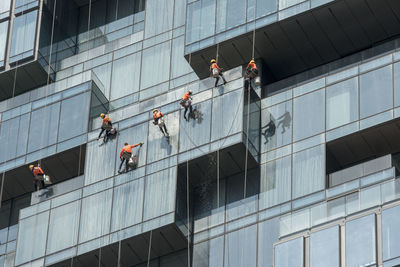 Low angle view of people working on building