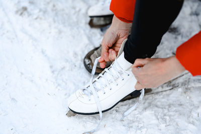 Pictured are hands tying ice skates. a young woman came to skate on an ice rink. winter fun