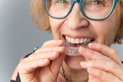 Portrait of senior woman holding dental aligner