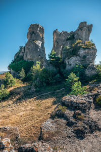 Rock formation on mountain against clear blue sky