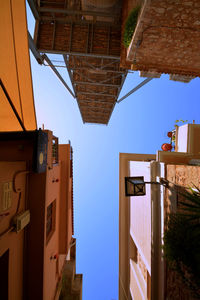 Low angle view of buildings against clear blue sky