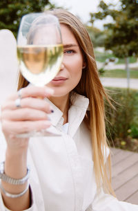 Young woman drinking wine in the park