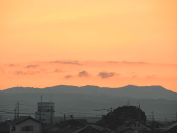 High angle view of silhouette cityscape against sky during sunset