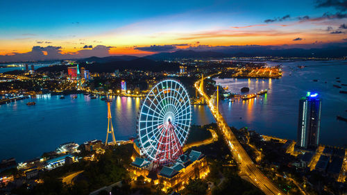 High angle view of illuminated cityscape against sky during sunset