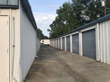 Empty footpath amidst buildings against sky