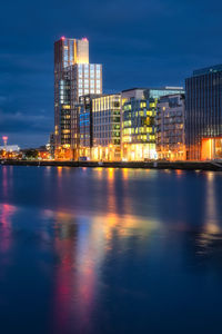 Modern offices and apartment buildings in docklands reflected in blurred liffey river at dusk dublin