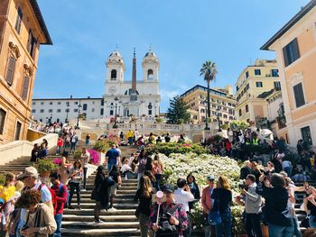 Group of people outside temple against buildings in city