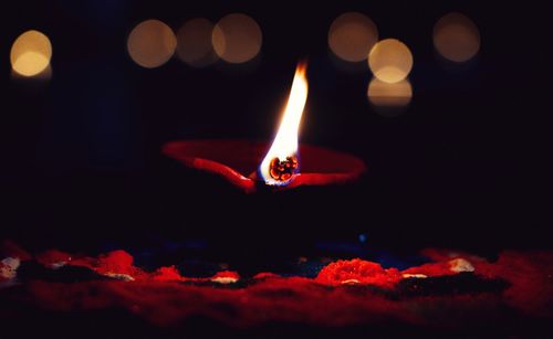 Close-up of lit diya in dark