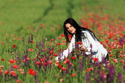 Young woman with flowers on field