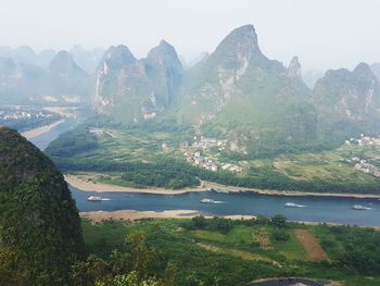 Scenic view of river and mountains against sky