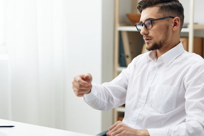 Portrait of man using mobile phone in office