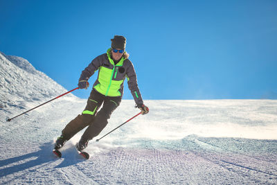 Man skiing on snow against mountain