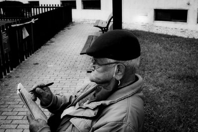 Man smoking cigarette while sitting outdoors