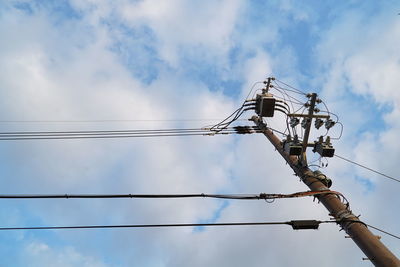 Low angle view of electricity pylon against sky