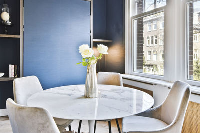 Flower vase on table by window at home