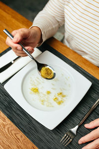 Midsection of woman having food on table