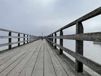 Footbridge over pier against sky