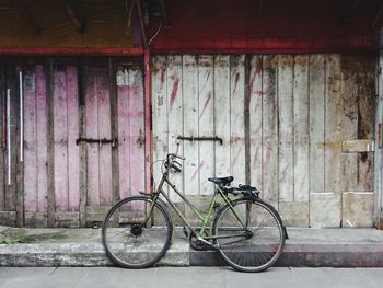 Bicycle parked against wall in city