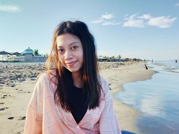 Portrait of beautiful woman sitting on beach