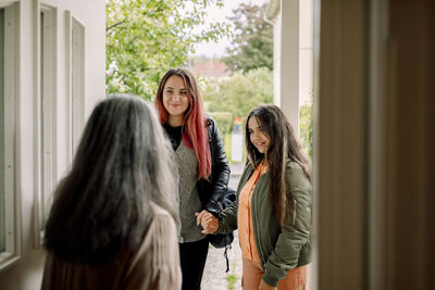 Happy woman visiting house of mother with daughter