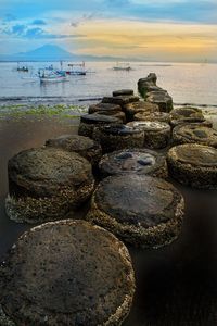 Stack of rocks on beach against sky during sunset