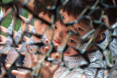 Reflection of cute boy seen in broken mirror pieces