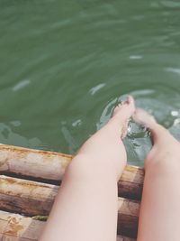 Low section of woman relaxing on lake