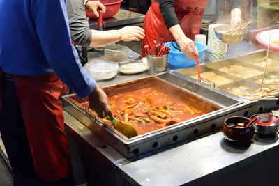 People working on barbecue grill