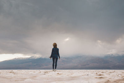 Full length of woman standing on landscape against sky