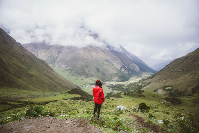 Rear view of woman on mountain against sky