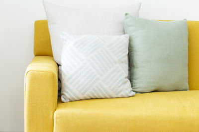 Decorative pillow on yellow leather sofa in living room.