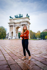Portrait of beautiful young woman against monument