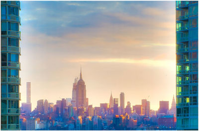 Buildings in city against cloudy sky