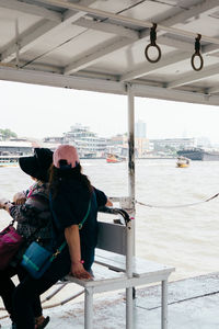 Rear view of man standing on boat in sea