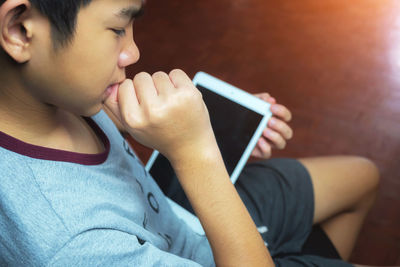 Midsection of boy using mobile phone