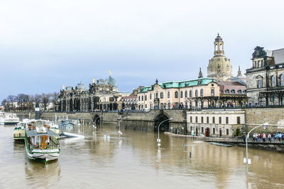 Boats in river with buildings in background