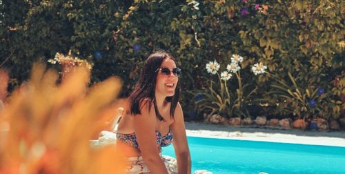 Portrait of young woman in sunglasses at swimming pool