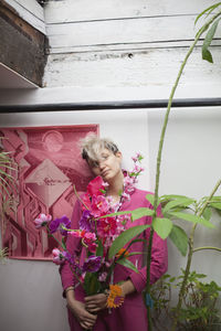 Woman standing by pink flowering plants