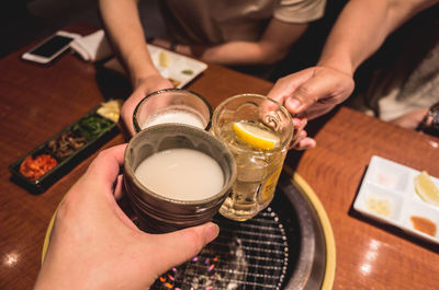 Cropped hands of friends toasting drinks at restaurant