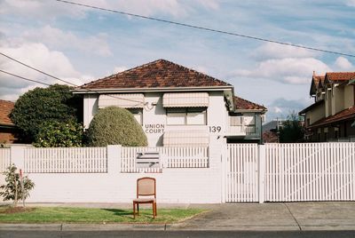 Houses by street against sky in city