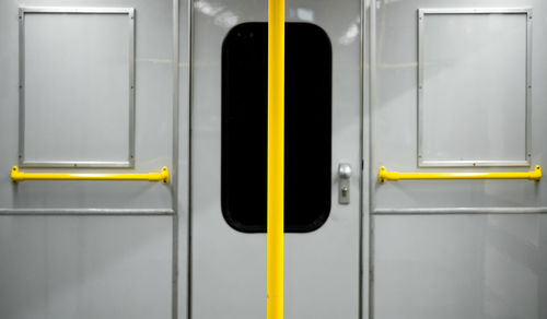Yellow pole against door in train
