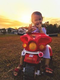 Portrait of boy on field against sky during sunset