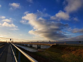 Bridge over road against sky during sunset